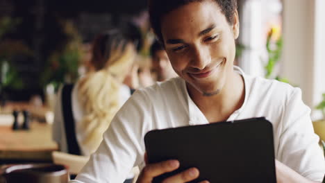 Mixed-race-man-using-digital-display-touchscreen-tablet-ipad-device-in-cafe