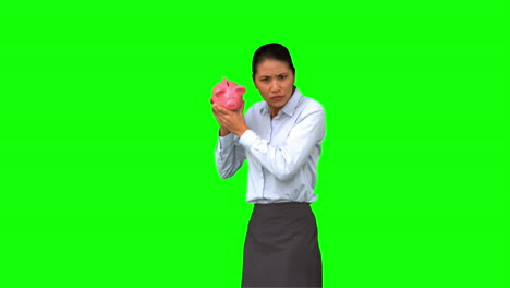 Businesswoman-shaking-an-empty-piggy-bank-on-green-screen