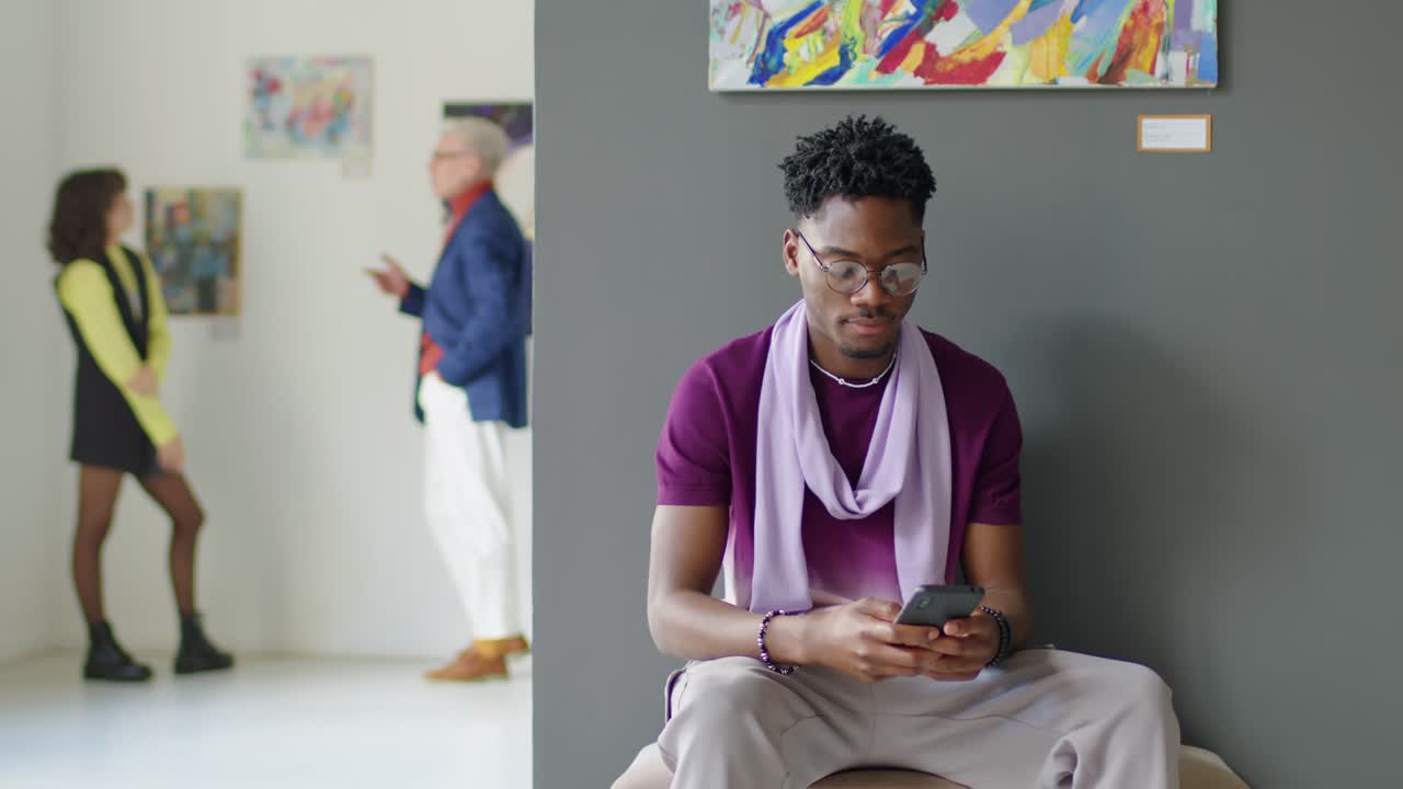 African American Man Using Smartphone in Art Gallery