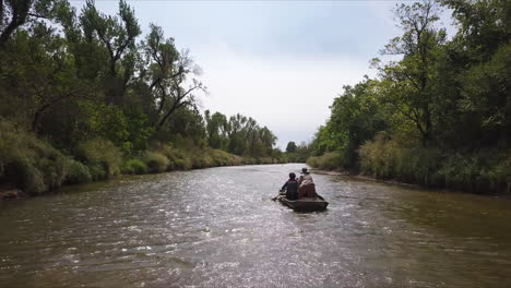 slow tracking shot of a family paddling upstream in a kayak, in georgia