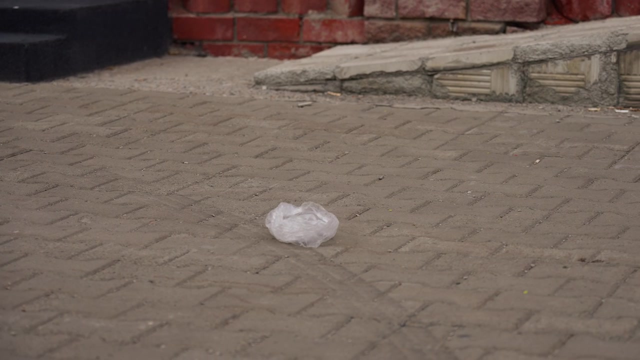 Busta di plastica accartocciata che giace sul marciapiede