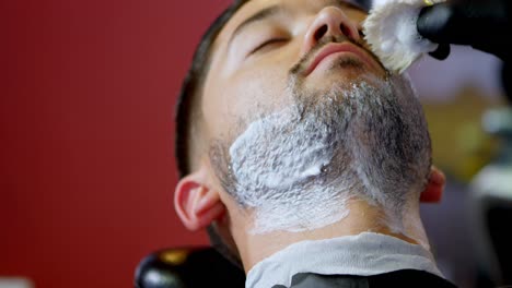 Barber-applying-shaving-cream-on-client-beard-4k
