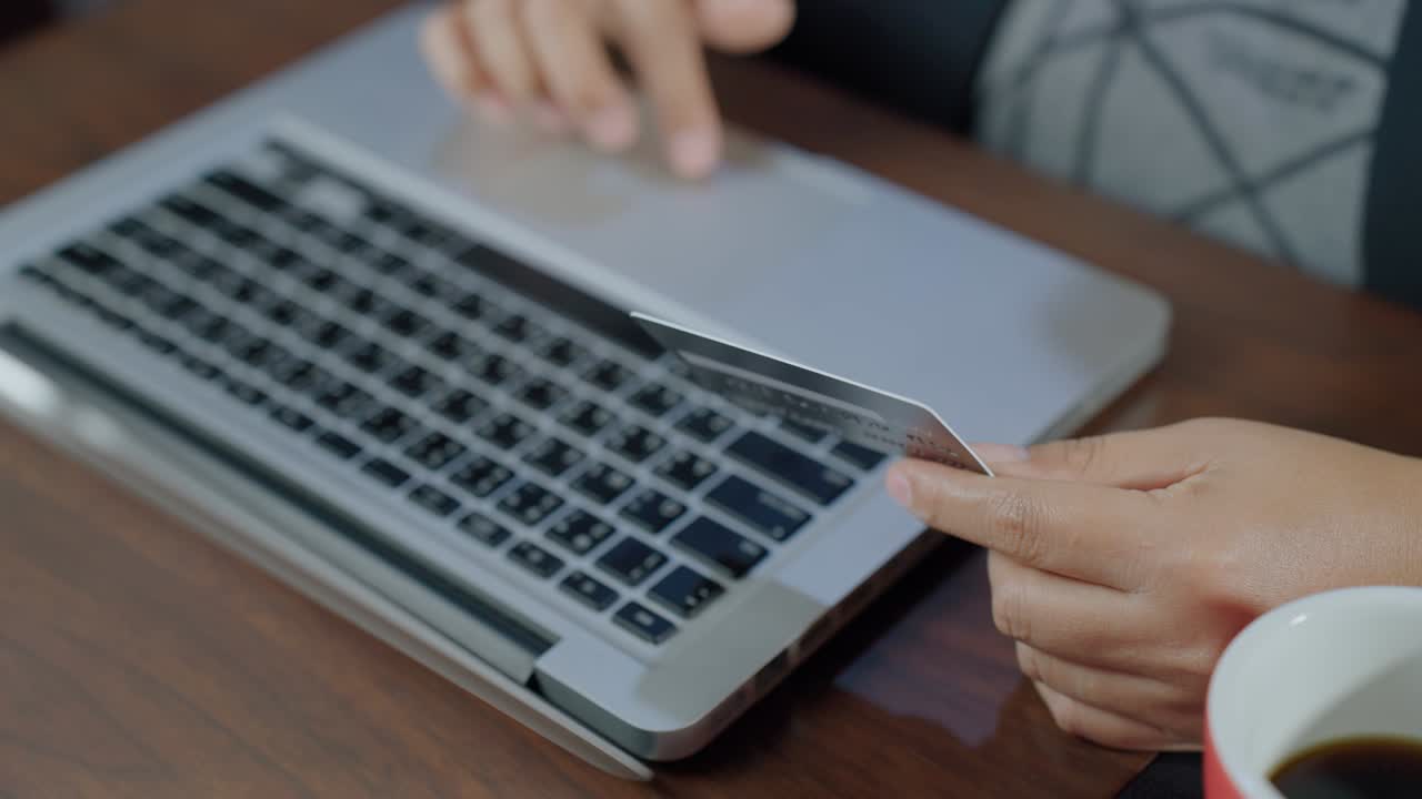 손의 느린 움직임으로 키보드를 입력하고 신용카드를 들고 온라인에서 쇼핑하는 것, 신용카드 소유자가 신용 카드를 들고 전자 은행에서 온라인 결제를 하는 것, 노트북을 사용하여 웹 스토어에서 구매를 지불하는 것.