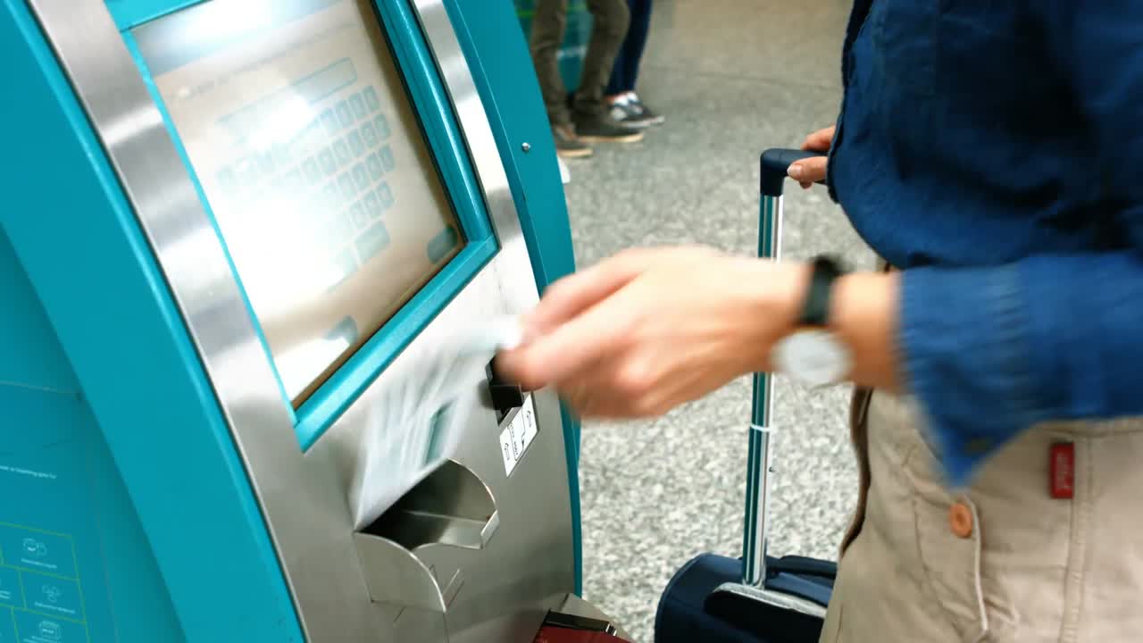 mujer viajera que utiliza la máquina de billetes de avión