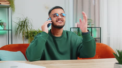 Happy-Indian-man-involved-in-pleasant-conversation-phone-call-good-news-enjoying-talking-gossip