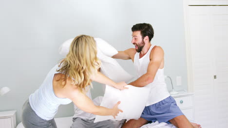happy family playing to pillows fight on bed