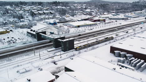 Aerial-view-of-train-onboarding-commuters-during-winter,-Alvangen-Sweden