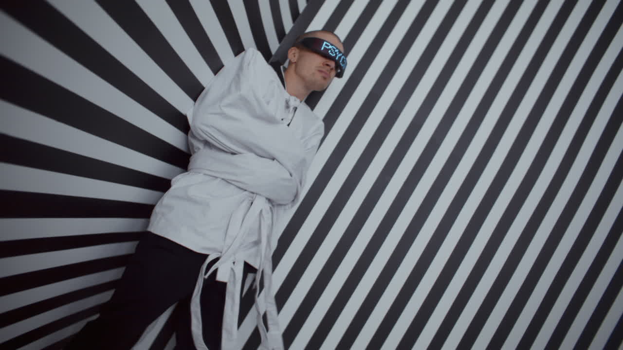 Man in Constraining Clothing in a Striped Room