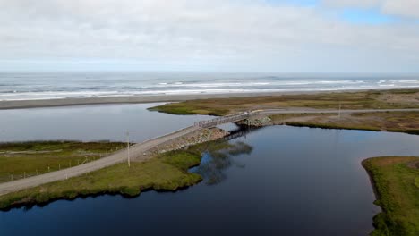 Aerial-view-of-a-truck-passing-the-Puente-De-Bote-bridge-in-Cucao,-Chiloé,-Chile