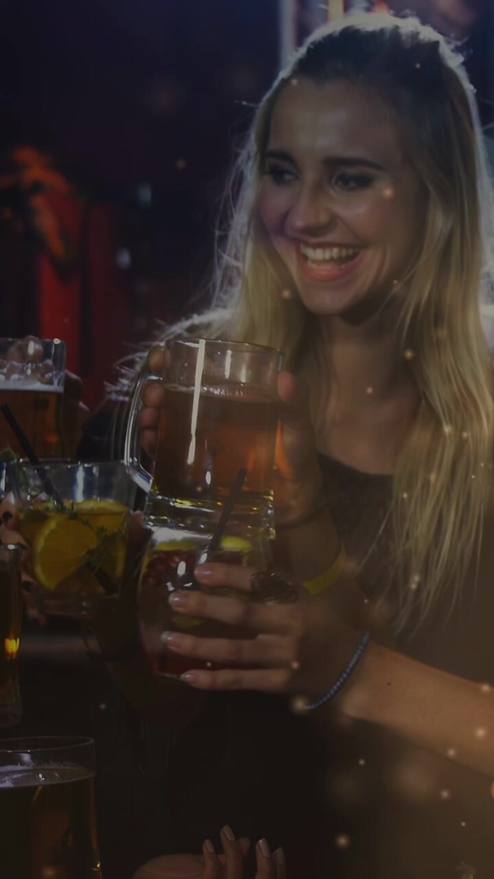 Video verticale: Cliente che solleva un boccale di birra dopo un'offerta, brindando al bar, luci animate intorno alle bevande
