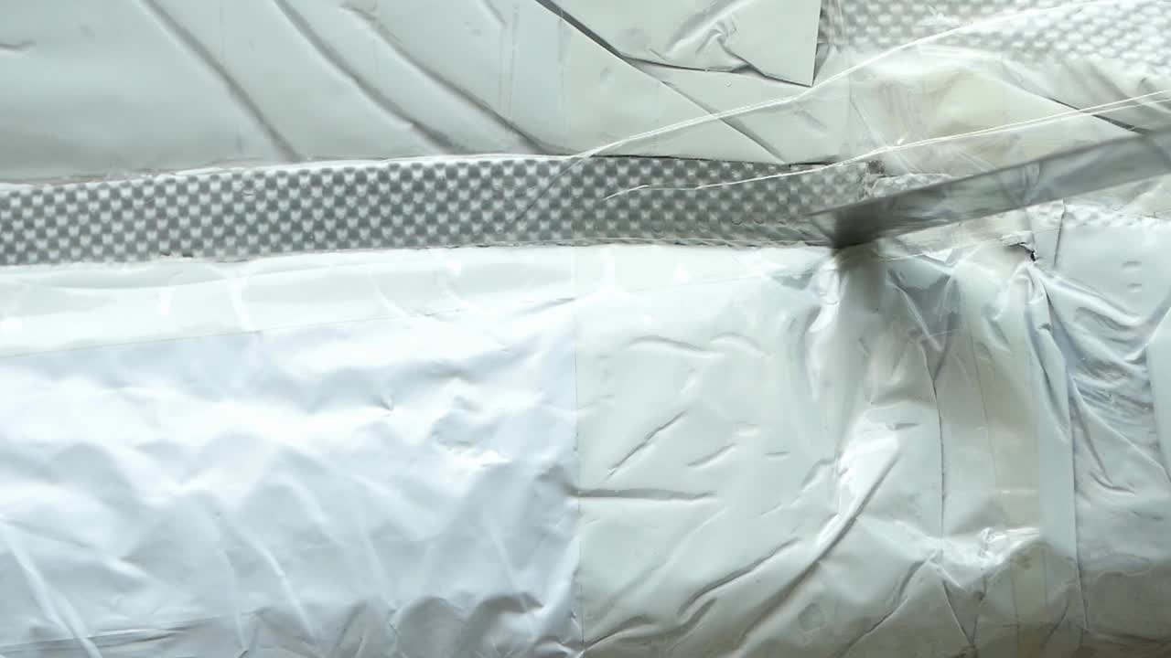 Close-up of White Plastic Packaging Being Opened