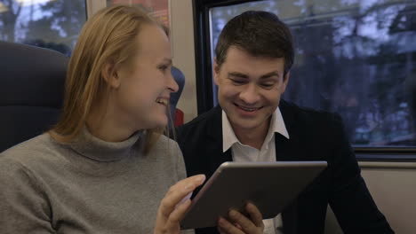 friends laughing while using pad in train