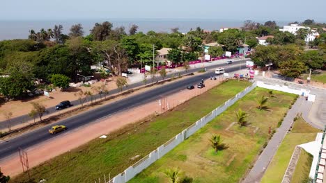 Establecimiento-De-Drone-Pan-Sobre-La-Carretera-De-La-Ciudad-De-Banjul-Y-El-Arco-22,-Gambia,-áfrica-Occidental