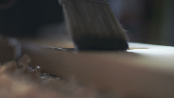 giovane che dipinge tavola di legno con una vernice marrone 4