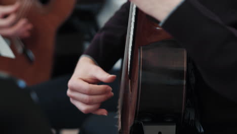 detail of a classical guitar and male hands playing on it