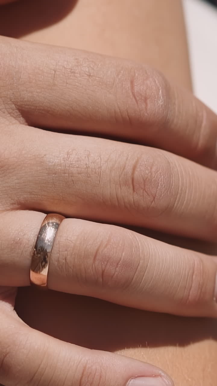 Loving man with wedding ring hugs young wife on summer day closeup slow motion. Newlywed young bride and groom. Lovely couple celebrates marriage