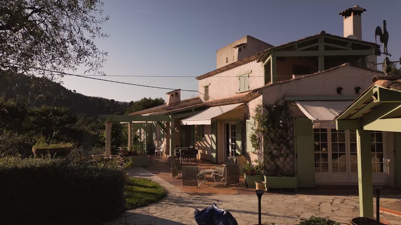 Sunlit Mediterranean villa in the French Riviera surrounded by lush garden and olive trees