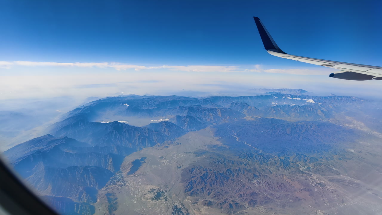 Aerial view of UAE dunes and mountains from an airplane in the afternoon