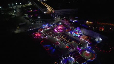 aerial view of pop-up carnival rides with colorful neon lights at night in philippines.