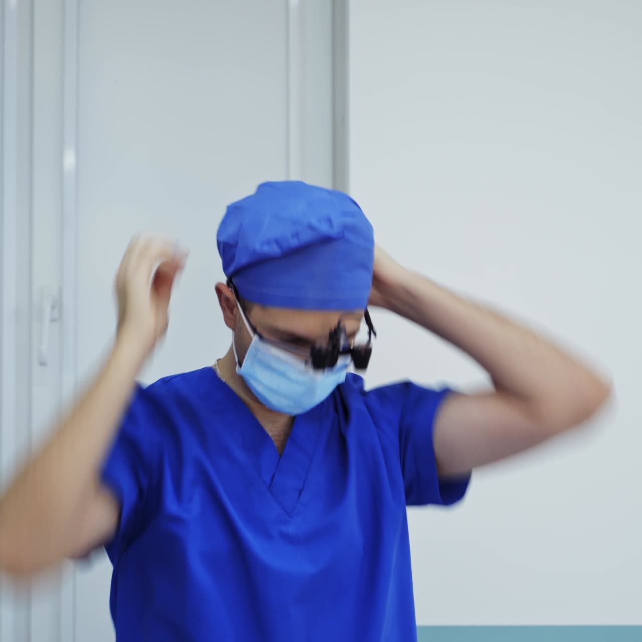 Doctor before the operation. Male surgeon puts on head torch in hospital operating theater. Professional doctor dressing medical flashlight before neurosurgery.