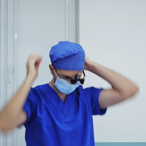 doctor before the operation. male surgeon puts on head torch in hospital operating theater. professional doctor dressing medical flashlight before neurosurgery.