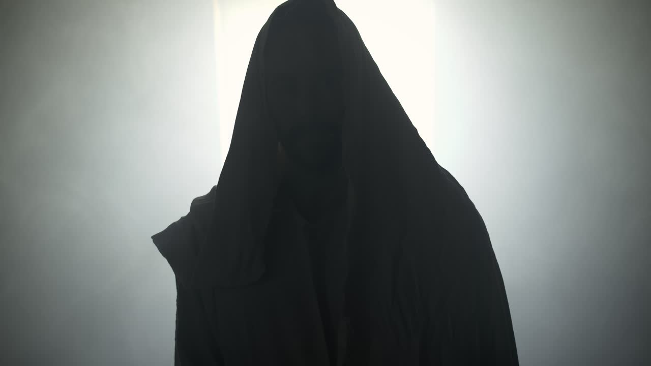 The resurrected Jesus Christ standing inside the tomb in bright, dramatic, holy light as representation of the Easter Sunday resurrection in cinematic slow motion.