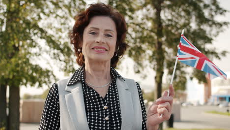 smiling senior woman holding the british flag