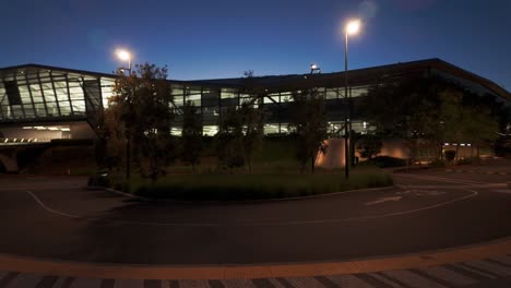 gimbal wide panning shot of a shuttle stop at the endeavor building on the nvidia campus at twilight in silicon valley, california. 4k