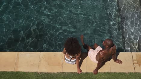 Happy-mixed-race-couple-enjoying-the-pool-during-a-sunny-day