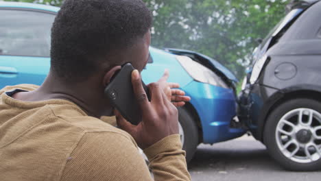 conductor masculino involucrado en un accidente automovilístico llamando a la compañía de seguros desde la carretera