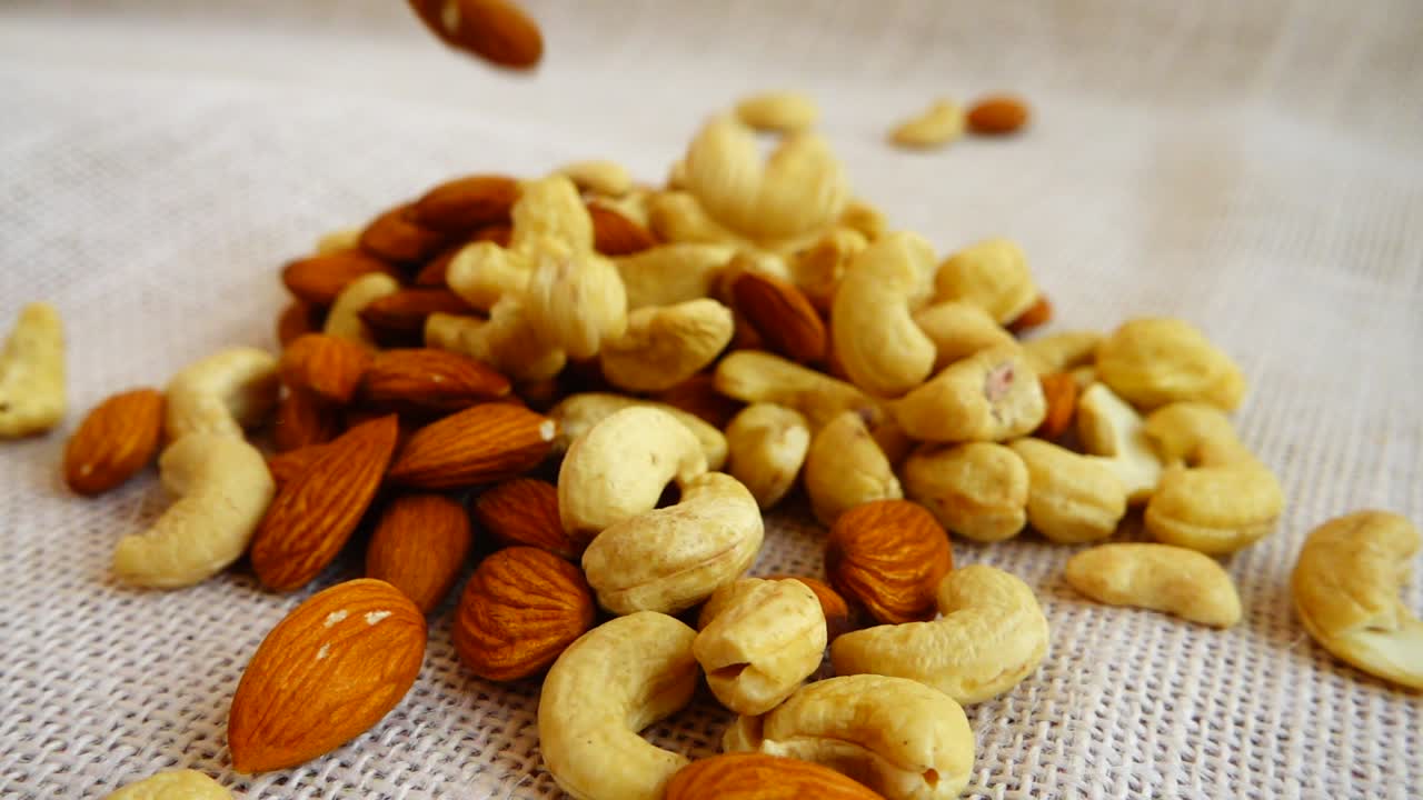 Almonds nuts and cashews nuts. Shooting while falling on a sack. Slow motion