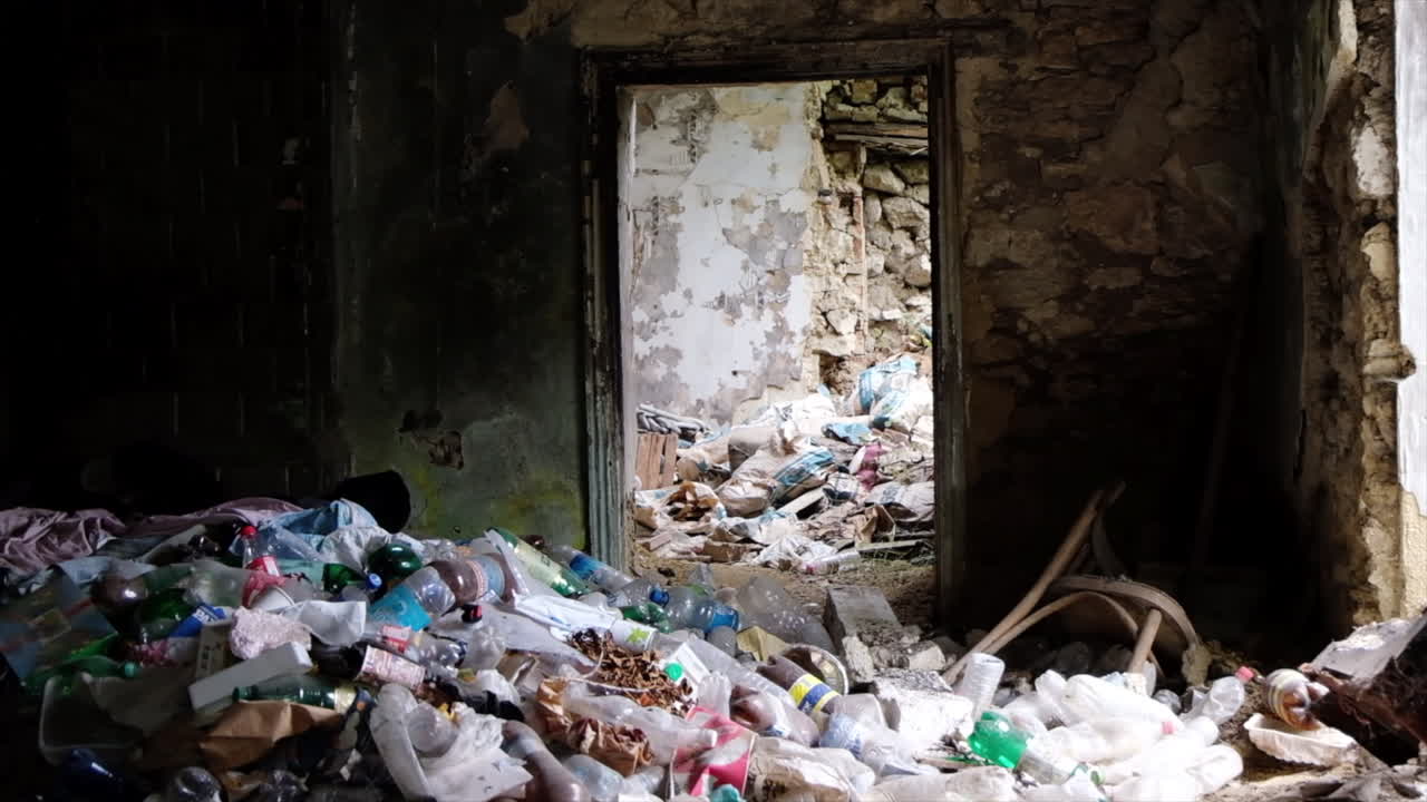 A pile of plastic bottles and garbage in an abandoned buiding