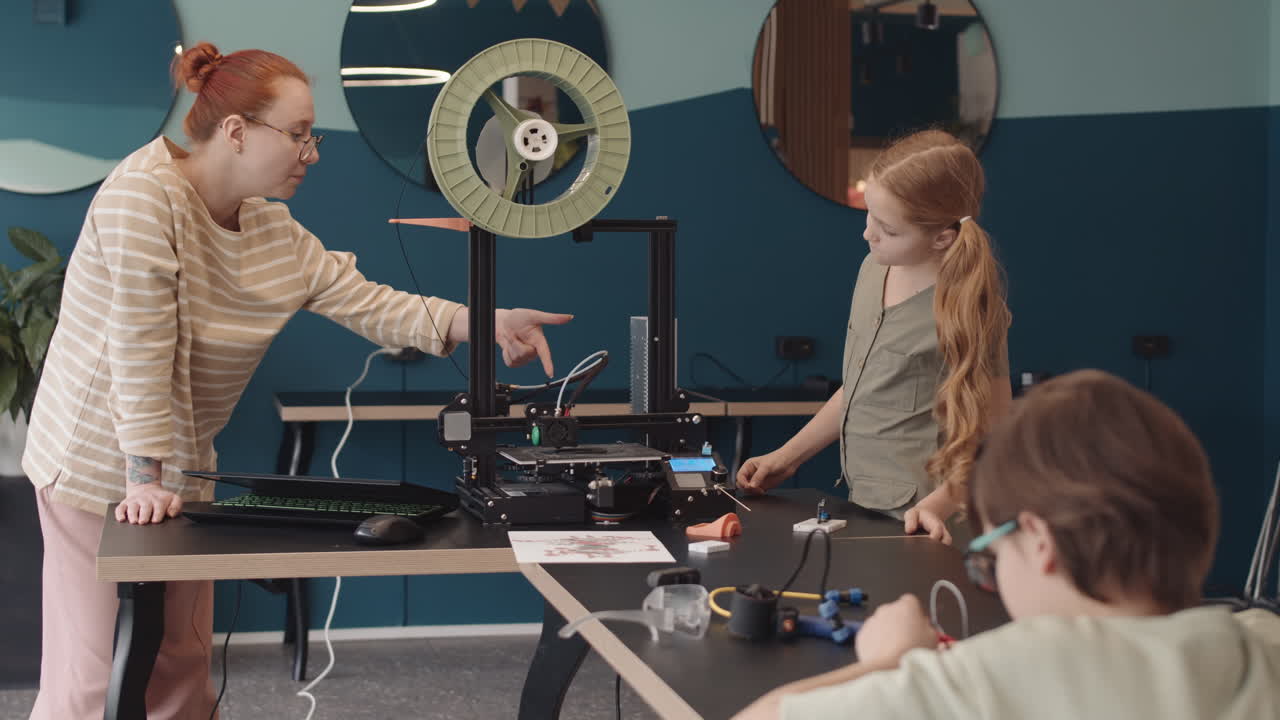 Teacher Explaining Schoolgirl How 3D Printer Works