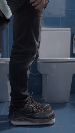person stepping on a weighing scale in a bathroom