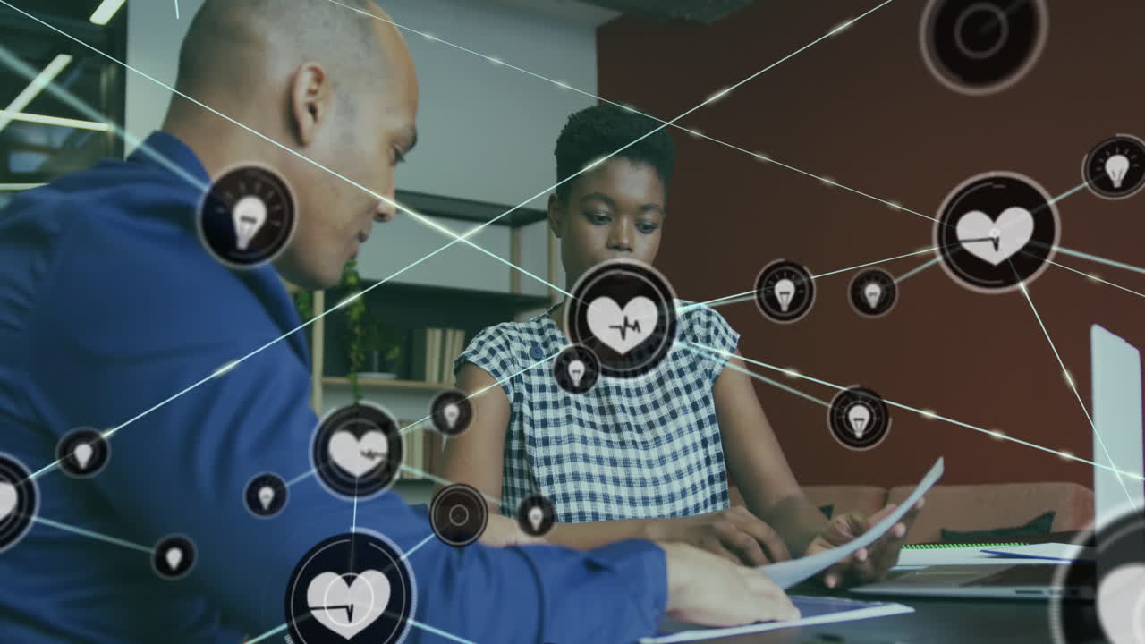 animación de iconos conectados sobre diversos compañeros de trabajo discutiendo informes en el escritorio en la oficina