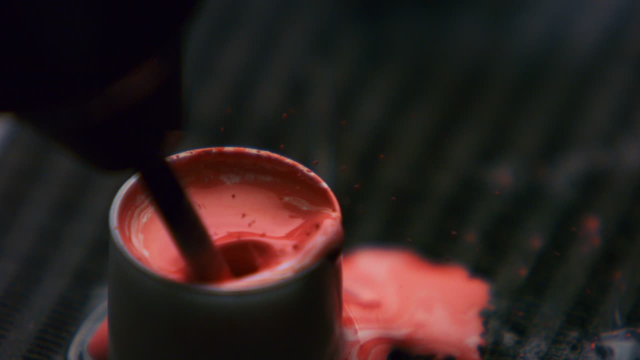 clouseau del artista del tatuaje mezclando tinta roja en tapas fijadas con vaselina en la mesa