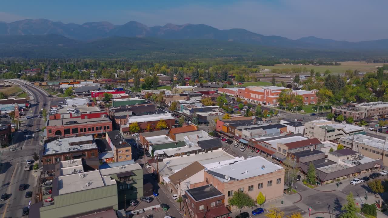 Distrito de negocios del centro de Whitefish, Montana, con calles y tejados bajo plena luz del día, vista aérea orbital.