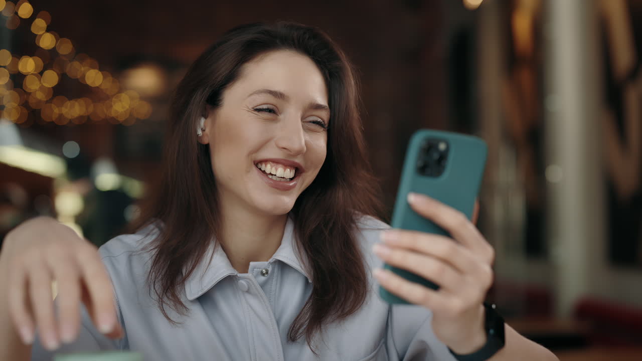 Smiling woman using smartphone indoors