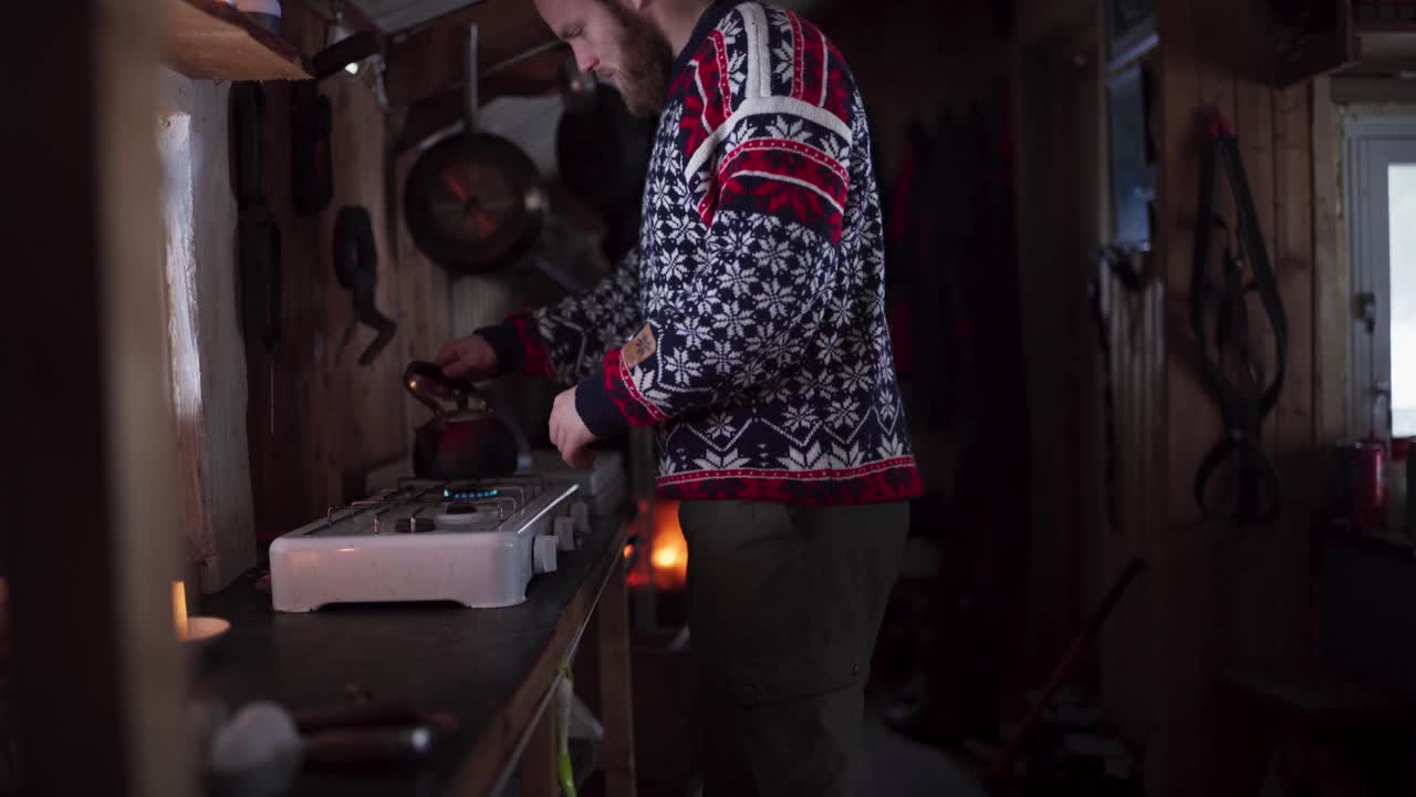 hombre entra en la cocina para apagar la estufa de gas después de calentar el agua en una tetera
