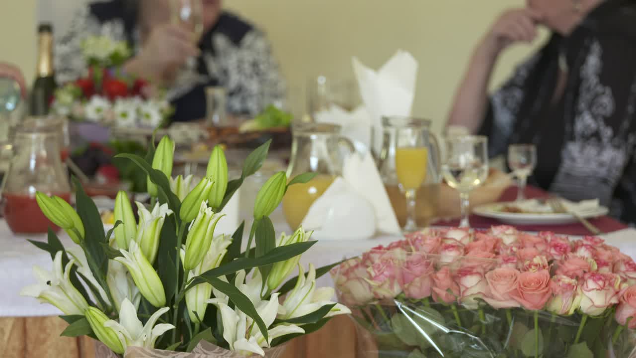 mesa de cena festiva decorada con arreglos florales de lirios y rosas