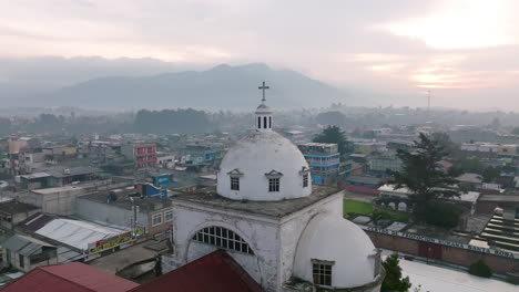 sobrevuelo aéreo lento sobre el campanario de la catedral que se encuentra en el centro de san juan ostuncalco durante el amanecer