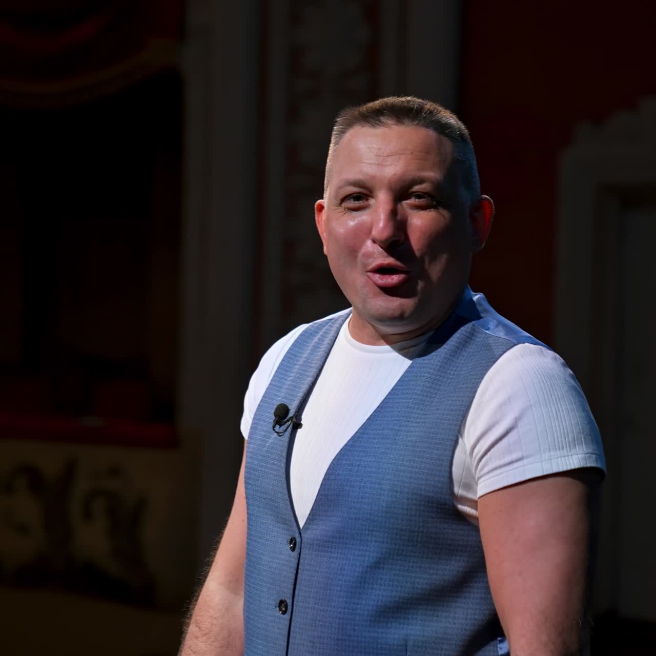 Actor puts facial mask off and annonces beginning of thater season beginning. Happy man on stage