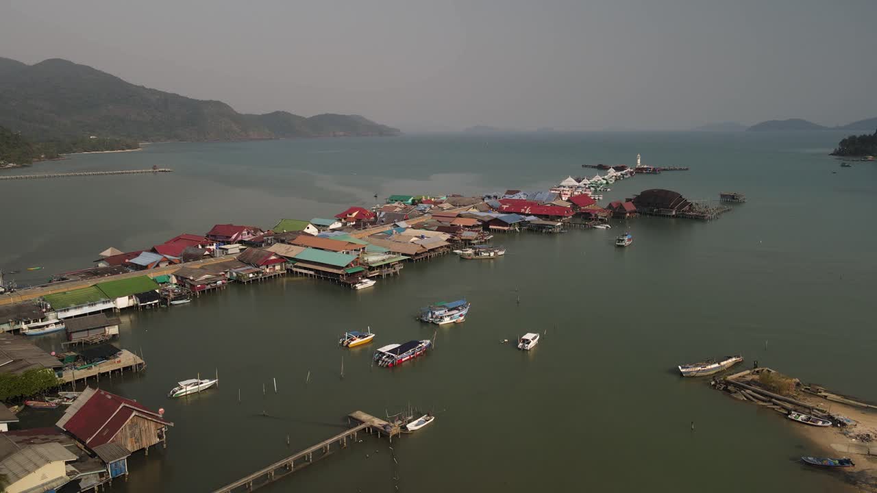 inclinación aérea ascendente sobre los barcos a lo largo del muelle de pesca bang bao en koh chang, tailandia