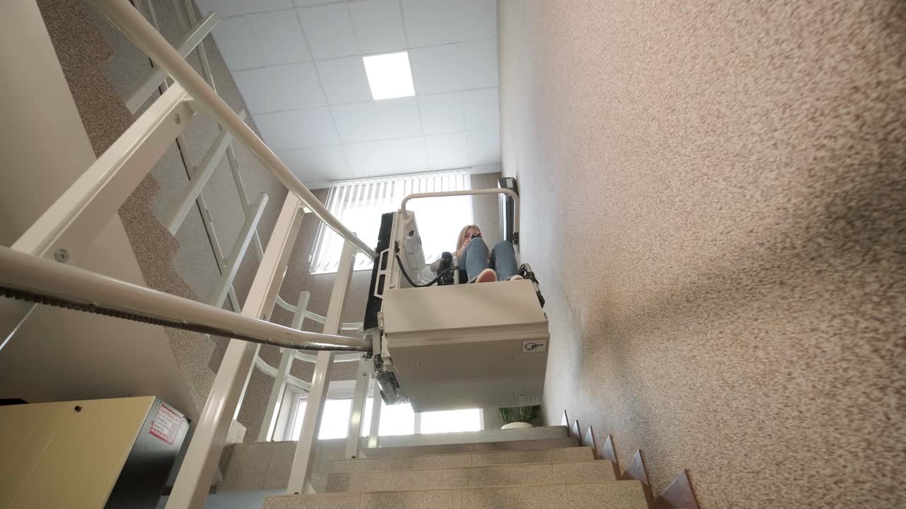 체어를 타고 있는 소녀가 계단 엘리베이터를 이용해 어렵지 않게 계단을 올라갑니다.