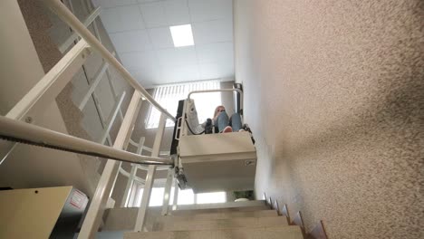 una niña en silla de ruedas sube las escaleras sin esfuerzo usando un ascensor de escaleras.