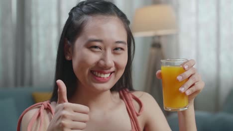 una mujer disfrutando de jugo de naranja.