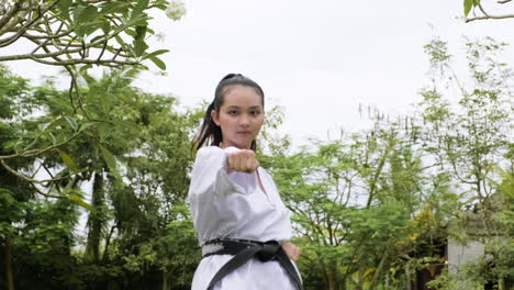 una mujer joven practicando taekwondo.