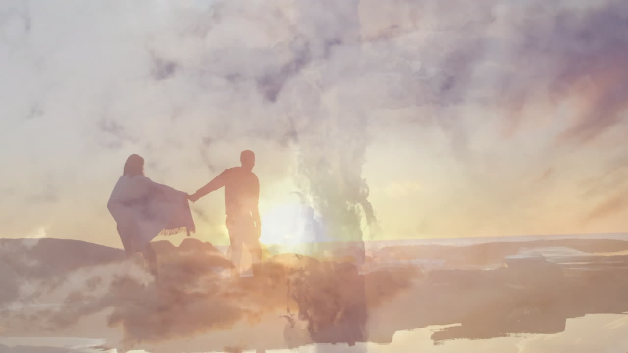 Walking on beach at sunset, silhouetted couple with dreamy animation effect