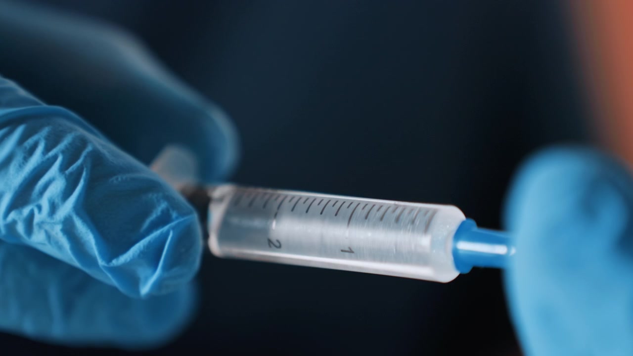 Macro syringe preparation by black paramedic inside ambulance, blue gloves, dosage markings visible, focused hands, siren glow through window, rapid response energy, sterile handling, calm