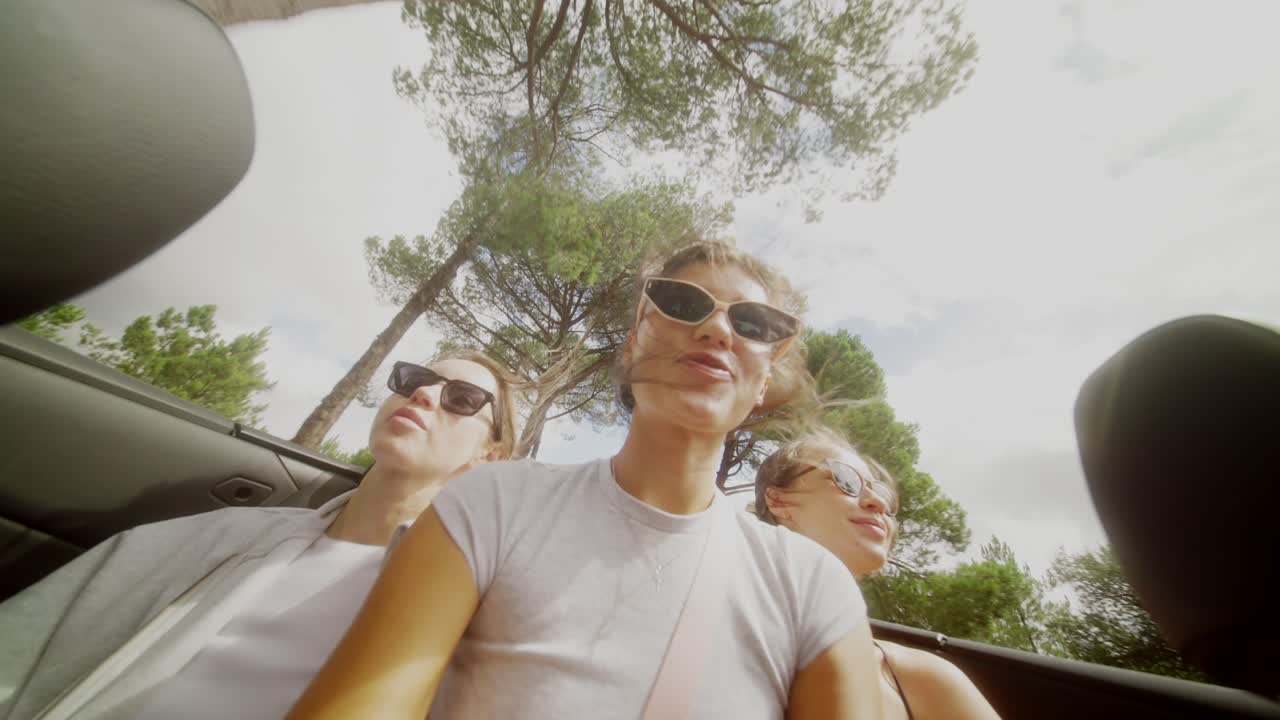 Three Women Enjoying a Road Trip in a Convertible